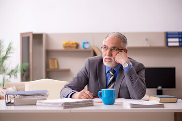 Obraz premium Old male employee working from home during pandemic