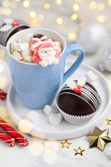 Festive hot chocolate bombs with marshmallows inside. Christmas dessert for making a drink. A blue mug of hot cocoa or chocolate. Selective focus