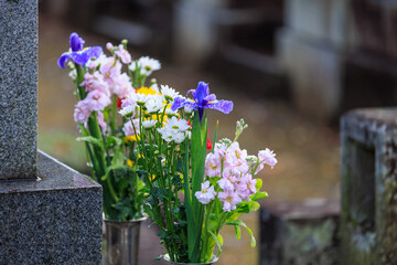 雨に濡れる墓と供花