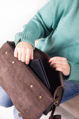 A businesslike young woman in jeans and a sweater with a leather briefcase