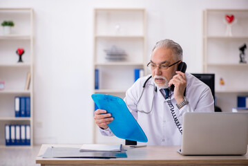 Old male doctor in telemedicine concept