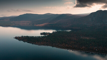 Landscape with lake and mountains in Stora Sjöfallet National Park in autumn in Lapland in Sweden from above during sunset.