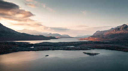 Landscape with lake and mountains in Stora Sjöfallet National Park in autumn in Lapland in Sweden from above during sunset.