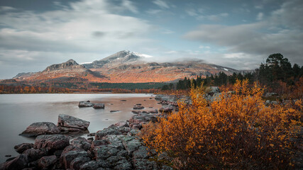 Mountain landscape with lake and rocks in Stora Sjöfallet National Park in autumn in Lapland in...