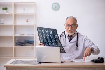 Old male doctor radiologist working at the hospital