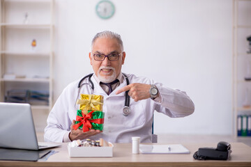 Old male doctor celebrating Christmas at the hospital