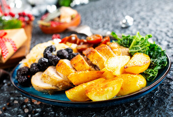 baked chicken breast with potatoes and olives on xmas background