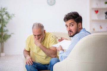 Old man visiting young male psychotherapist