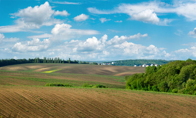 Fototapeta na wymiar Plowed field and hills in a rural landscape at spring