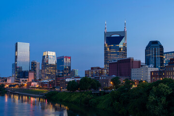 Obraz premium Panoramic view of Broadway district of Nashville over Cumberland River at illuminated night skyline, Tennessee, USA. This city is known as a center for the music industry, especially country music