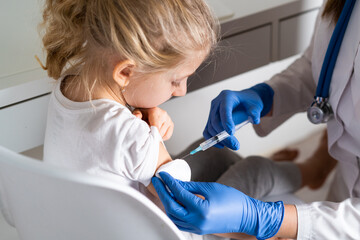 Naklejka premium vaccination of children, a little girl at a doctor's appointment, an injection in the arm, the conce