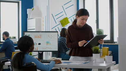 Businesswoman discussing with invalid disabled paralysed african woman company development plan....