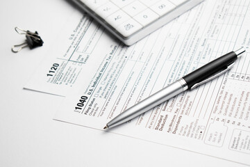 Pen on US TAX form Background. Tax Day concept