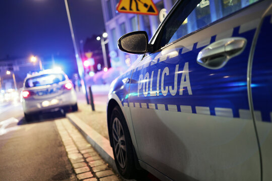 Polscy policjanci i ich pojazdy podczas wieczornej służby w mieście. 
