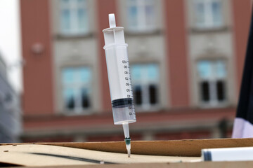 Fototapeta Strzykawka ze szczepionką wbita w jakieś podłoże.  obraz