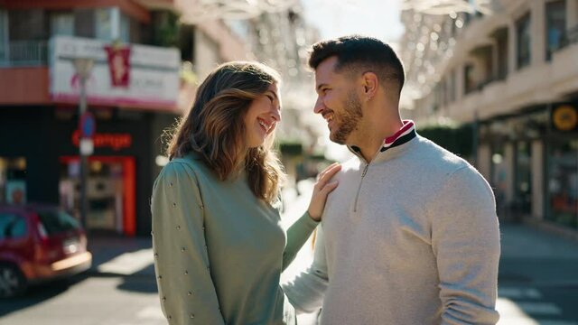 Young couple smiling confident hugging each other standing at street
