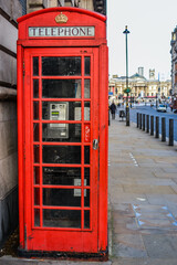 Obraz premium UK, London, 11.12.2021: Red telephone booth, symbol of London, on the street leading to the Trafalgar Square.