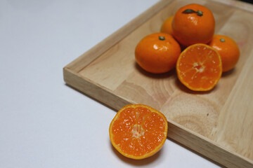 Ripe mandarins on a wooden cutting board on the table