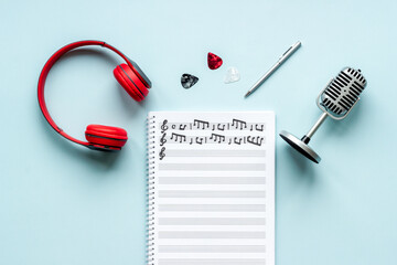 Handwritten music sheets and headphones, top view. Compose music concept