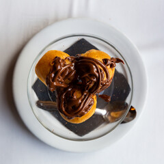 Fototapeta premium Profitroles de nata con chocolate caliente, cream profiteroles with hot chocolate
