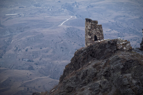 Towering amidst Caucasus. Ossetian tribal tower on top of a rocky mountain in Fiagdon Gorge of North Ossetia-Alania Republic in Russia