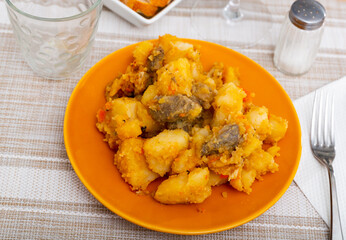 Braised beef with baked potato served with mayonnaise sauce in a restaurant