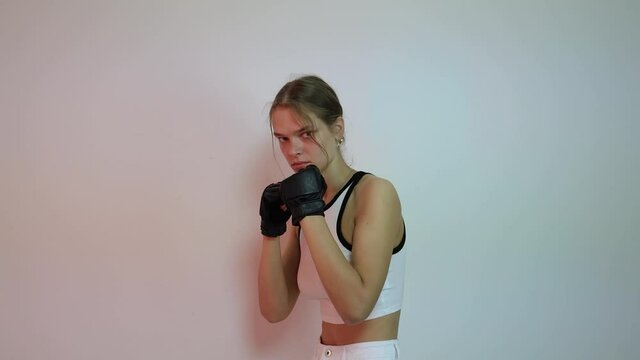 Young female boxer practicing shadowboxing
