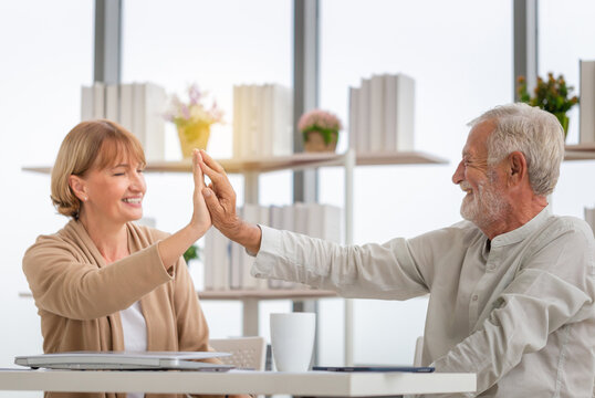 Happy senior couple in living room, Smiling older couple giving high five, Happiness family and retirement concepts