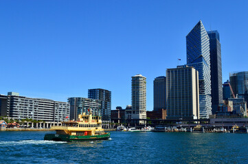 Fototapeta na wymiar A ferry pulls into the busy Circular Quay Ferry Terminal in Sydney, Australia