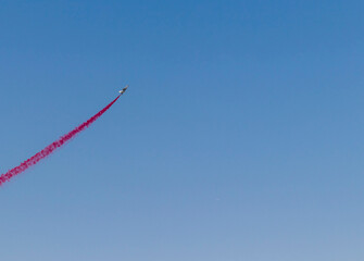 Military airplane performing stunts in clear blue sky. Airshow