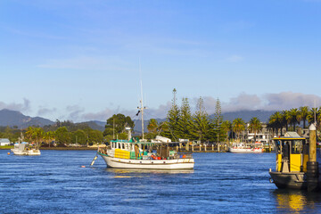 Fototapeta premium Boats and Landscape Scenery at Ferry Landing Port, Coromandel Peninsula New Zealand During Morning Time