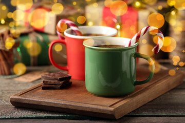 Mugs of delicious hot chocolate on wooden table