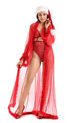 Sexy young woman in Santa hat and underwear on white background