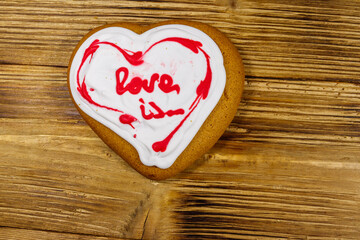 Obraz na płótnie Canvas Heart shaped gingerbread cookie on wooden table. Top view. Dessert for valentine day