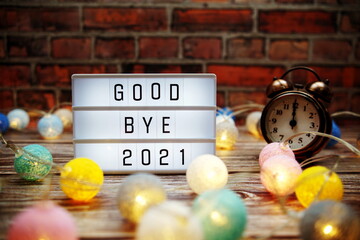 Goodbye 2021 text in light box with alarm clock and LED cotton balls decoration