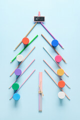 Christmas tree made of painter's tools on light background