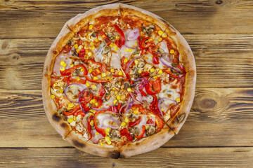 Delicious fresh pizza on a wooden table. Top view