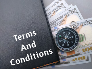 Selective focus.Text Terms And Conditions with notebook,compass and banknotes on gray background.