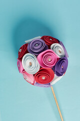 Rose sphere made of white, purple, red and pink foami on a blue background. Multicolored abstract...