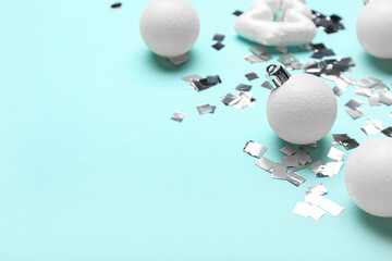 White Christmas decorations and confetti on blue background, closeup
