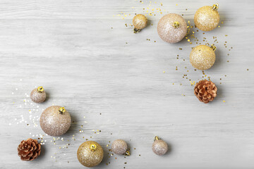 Beautiful Christmas balls and confetti on light wooden background