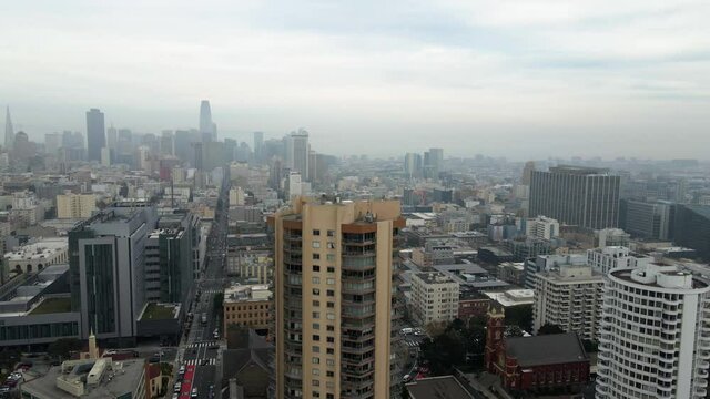 Aerial view revealing the Tenderloin district in cloudy San Francisco - rising, tilt, drone shot