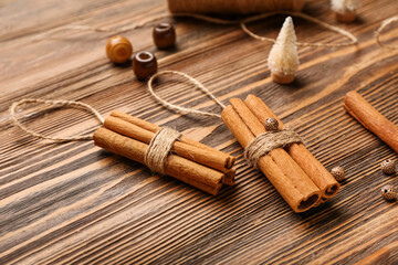 Handmade Christmas decorations made of cinnamon sticks on wooden background, closeup