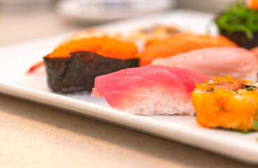 Focus on fresh Tuna Sushi or Maguro Sushi on white plate, mix Sushi together in one plate, close up image, selected focus.
