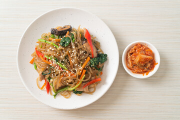 japchae or stir-fried Korean vermicelli noodles with vegetables and pork topped with white sesame - obrazy, fototapety, plakaty