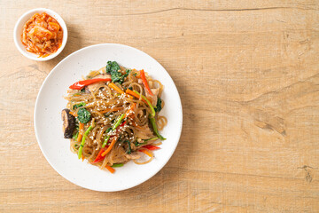 japchae or stir-fried Korean vermicelli noodles with vegetables and pork topped with white sesame