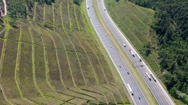 Aerial landscape of Bandeirantes highway road at countryside mountains. Landmark highway road between mountains. Rural landscape. Traffic at road. Scenic freeway road.