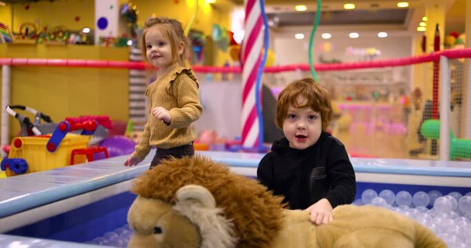 delighted kids having fun in play center, leisure activity in amusement park. colorful playroom