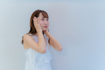 耳をふさぐポーズをする女性