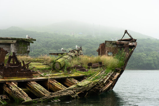 Abandoned antique old wooden ship at sea tropical landscape surrounded by fog